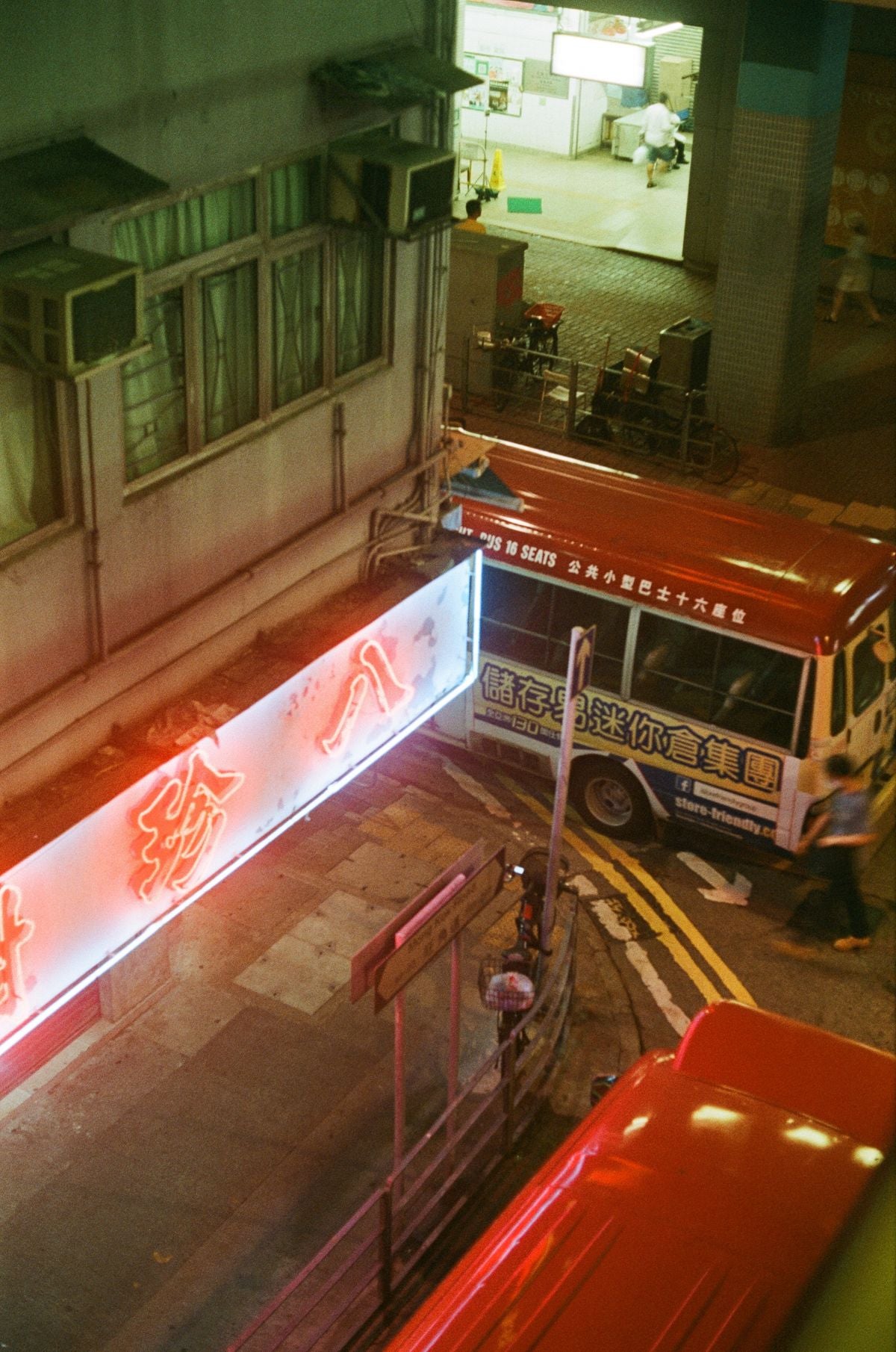 Neon signs above a Hong Kong bus at night — the perfect visual for transit vocabulary